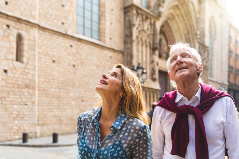 Senior couple of tourists visiting the old town in Barcelona Senior couple of tourists visiting the old town in Barcelona. Adult woman and man looking up at some beautiful architecture on a sunny day in Spain. Travel and tourism concepts